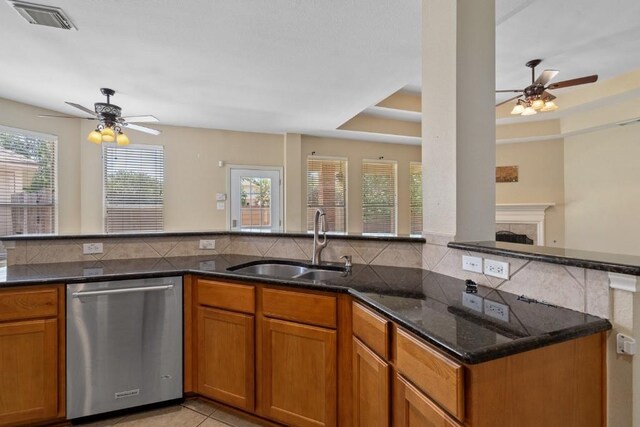 13617 Sun Dapple Ct, Manor, TX 78653 - kitchen with dishwasher, a ceiling fan, a sink, tasteful backsplash, and brown cabinets