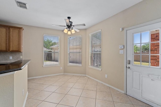 13617 Sun Dapple Ct, Manor, TX 78653 - unfurnished dining area featuring ceiling fan, light tile patterned flooring, and baseboards