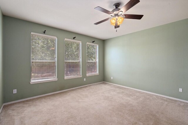 13617 Sun Dapple Ct, Manor, TX 78653 - carpeted empty room featuring plenty of natural light, a ceiling fan, and baseboards