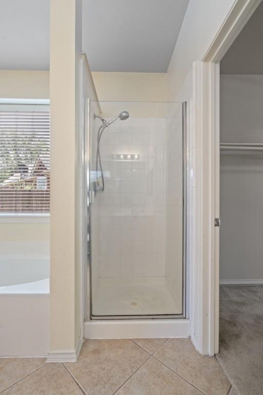 13617 Sun Dapple Ct, Manor, TX 78653 - full bathroom with a stall shower, a bath, tile patterned floors, and a spacious closet