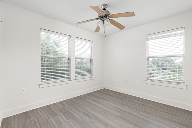 1601 Miriam Ave Unit 210, Austin, TX 78702 - empty room featuring healthy amount of natural light, wood finished floors, a ceiling fan, and baseboards