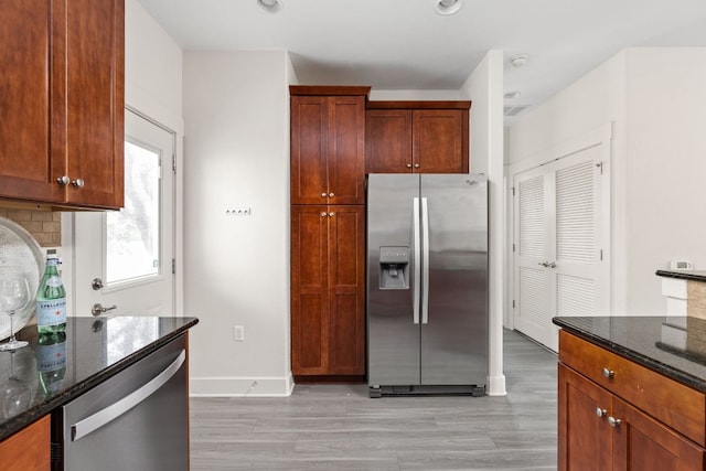 1601 Miriam Ave Unit 210, Austin, TX 78702 - kitchen featuring appliances with stainless steel finishes, dark stone counters, light wood-style flooring, baseboards, and recessed lighting
