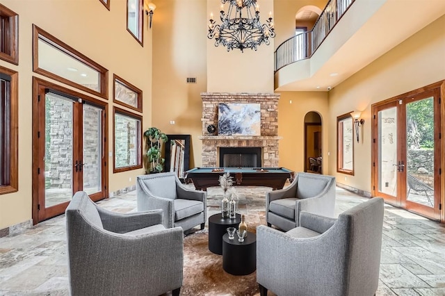 312 Camino Arbolago, Lakeway, TX 78734 - living area featuring french doors, billiards, a towering ceiling, arched walkways, and a chandelier