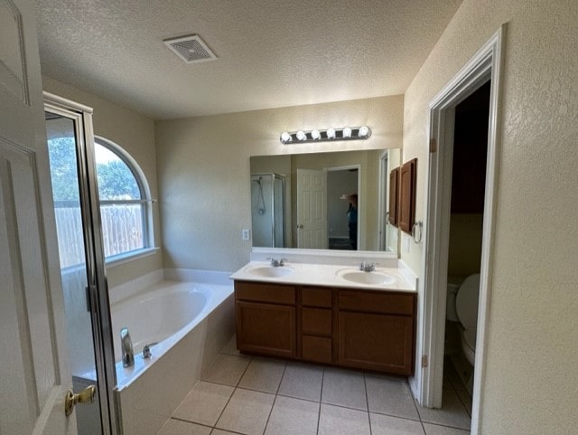 221 Roadrunner Ave, New Braunfels, TX 78130 - full bath featuring a garden tub, double vanity, toilet, tile patterned floors, and a textured ceiling