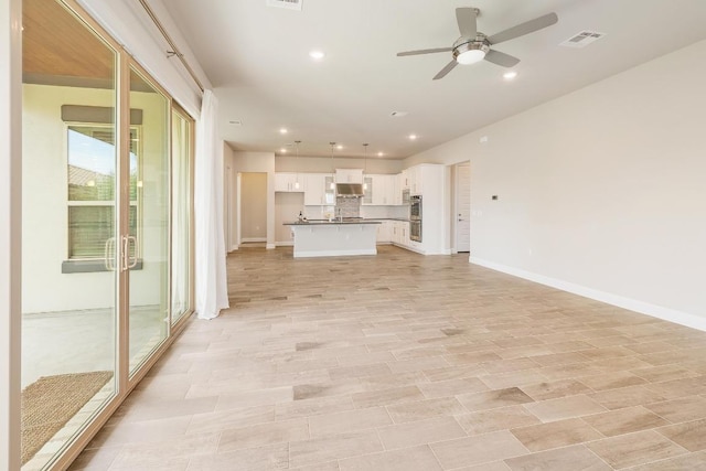 2613 Ibaza Bnd Unit 58, Leander, TX 78641 - unfurnished living room with ceiling fan, recessed lighting, baseboards, and a sink
