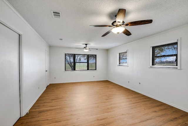 14615 Armstrong Rd, Salado, TX 76571 - unfurnished room featuring light wood-style flooring, healthy amount of natural light, a textured ceiling, crown molding, and ceiling fan