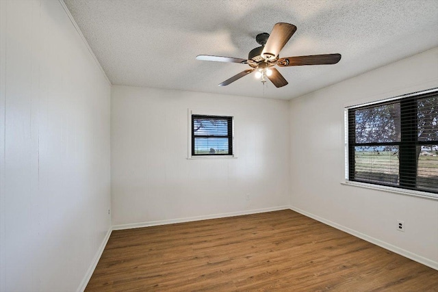 14615 Armstrong Rd, Salado, TX 76571 - empty room featuring a textured ceiling, wood finished floors, a ceiling fan, and baseboards