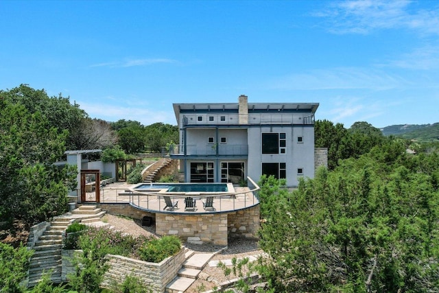 8207 Moon Rise Trl, Jonestown, TX 78645 - back of property with stairs, a balcony, a patio, a hot tub, and stucco siding