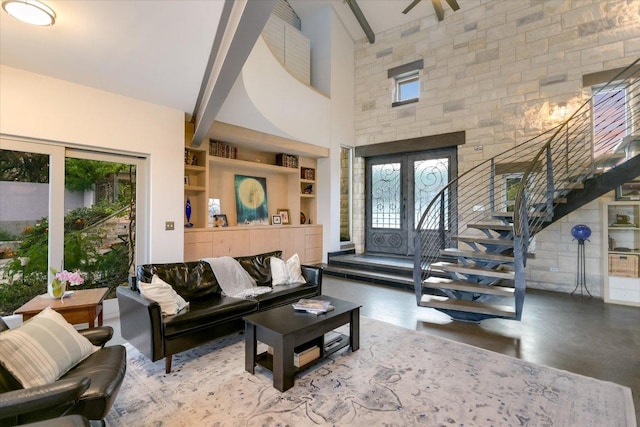 8207 Moon Rise Trl, Jonestown, TX 78645 - living room with stairway, a high ceiling, and built in shelves