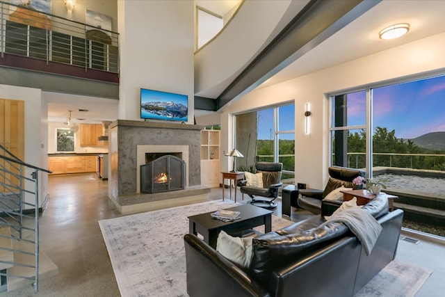 8207 Moon Rise Trl, Jonestown, TX 78645 - living room featuring a high end fireplace, plenty of natural light, stairway, and a high ceiling