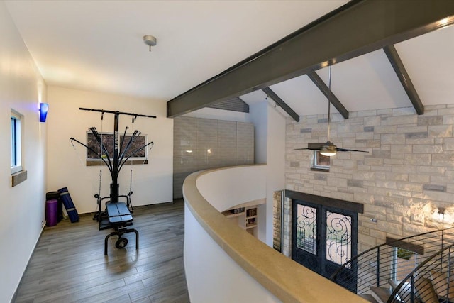 8207 Moon Rise Trl, Jonestown, TX 78645 - staircase featuring beam ceiling, a ceiling fan, wood finished floors, and a stone fireplace