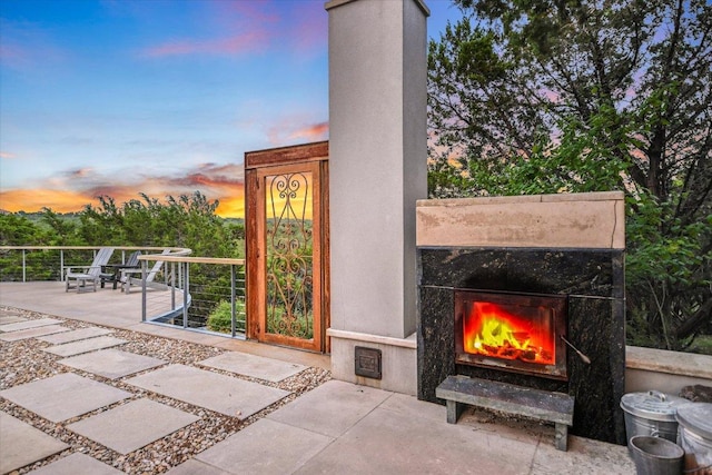8207 Moon Rise Trl, Jonestown, TX 78645 - patio terrace at dusk with a premium fireplace and a patio