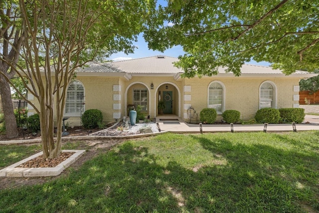 606 Explorer, Lakeway, TX 78734 - mediterranean / spanish-style house featuring a metal roof, a front lawn, and brick siding