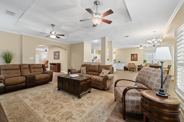 606 Explorer, Lakeway, TX 78734 - living room featuring a ceiling fan, a raised ceiling, light wood-style flooring, and arched walkways