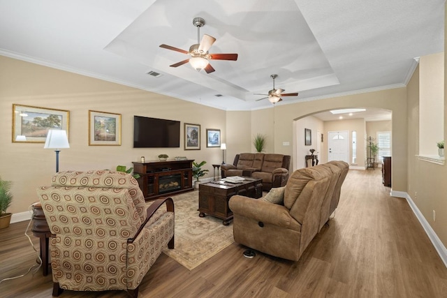 606 Explorer, Lakeway, TX 78734 - living area featuring arched walkways, a raised ceiling, wood finished floors, and crown molding
