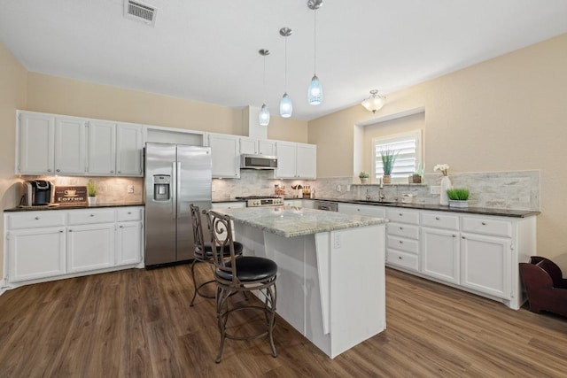 606 Explorer, Lakeway, TX 78734 - kitchen with appliances with stainless steel finishes, decorative backsplash, and dark wood-type flooring