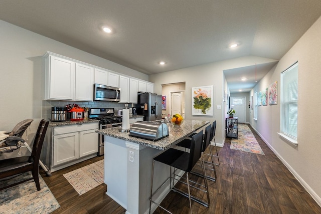 221 Tributary Way, Bastrop, TX 78602 - kitchen featuring appliances with stainless steel finishes, dark wood-type flooring, white cabinets, backsplash, and recessed lighting