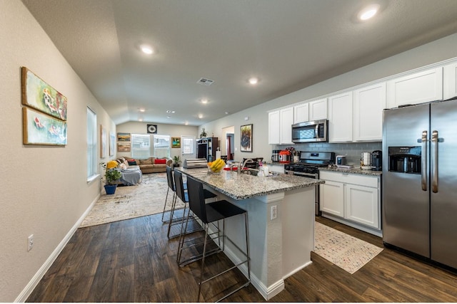 221 Tributary Way, Bastrop, TX 78602 - kitchen with appliances with stainless steel finishes, dark wood finished floors, open floor plan, light stone countertops, and white cabinetry