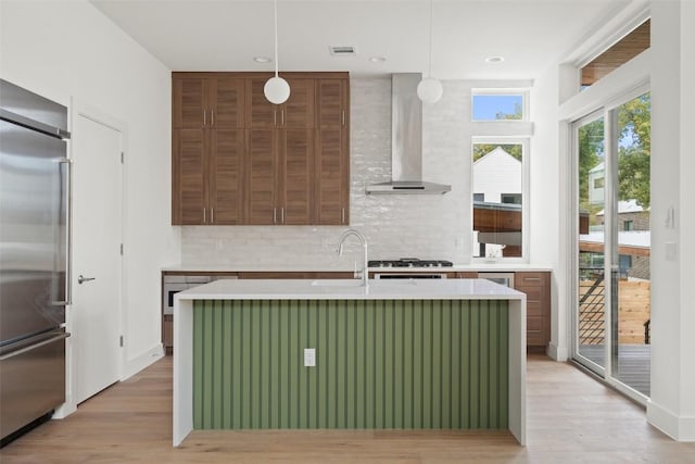 900 S 2nd St Unit 21, Austin, TX 78704 - kitchen featuring built in refrigerator, wall chimney range hood, a sink, backsplash, and light wood-type flooring