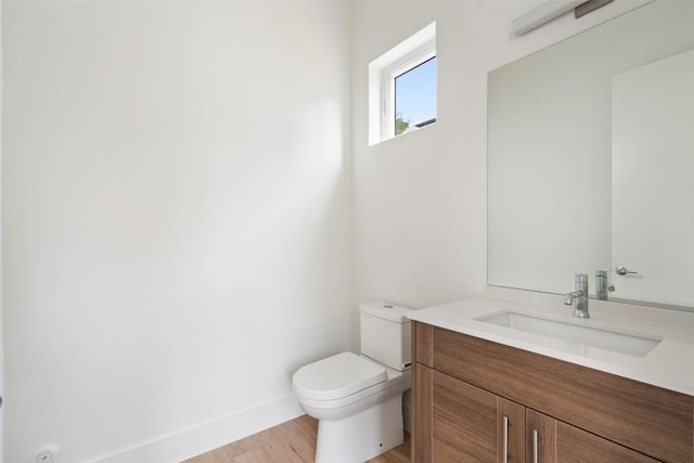 900 S 2nd St Unit 21, Austin, TX 78704 - half bathroom with toilet, baseboards, vanity, and wood finished floors