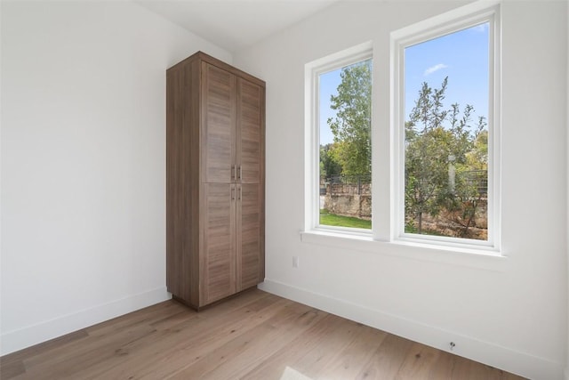 900 S 2nd St Unit 21, Austin, TX 78704 - unfurnished bedroom featuring baseboards, multiple windows, and light wood-style flooring