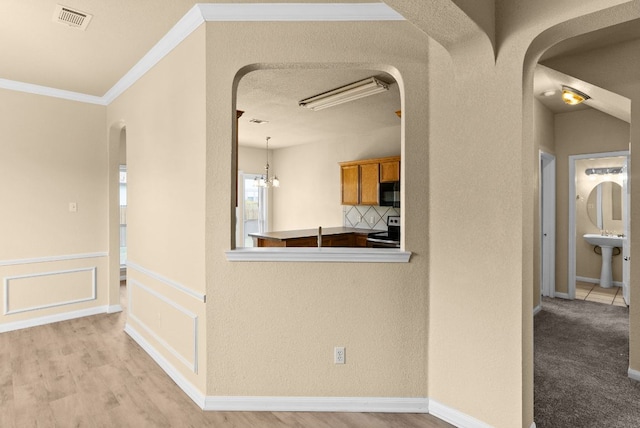 118 Lone Shadow Dr, Harker Heights, TX 76548 - kitchen featuring stainless steel range with electric cooktop, arched walkways, black microwave, crown molding, and brown cabinets