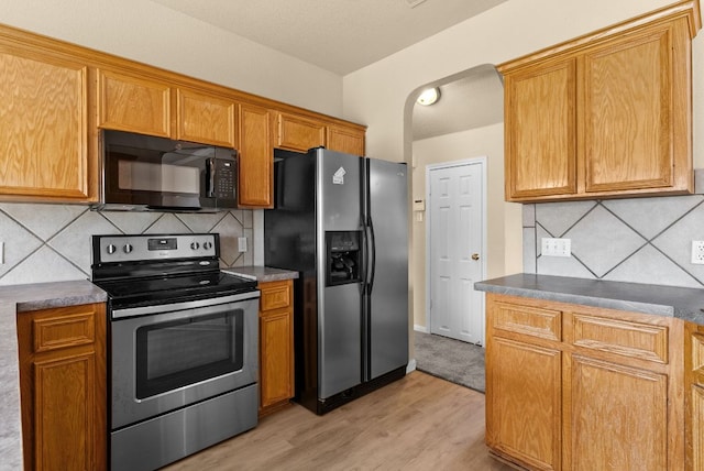 118 Lone Shadow Dr, Harker Heights, TX 76548 - kitchen with stainless steel appliances, light wood-style floors, tasteful backsplash, brown cabinets, and dark countertops