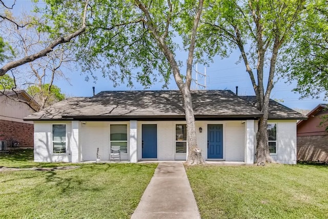 312 W William Cannon Dr, Austin, TX 78745 - view of front of home featuring brick siding, a front lawn, roof with shingles, and central AC unit