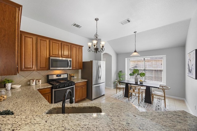 805 Meadow Bluff Ct, Round Rock, TX 78665 - kitchen featuring appliances with stainless steel finishes, a sink, light tile patterned flooring, brown cabinetry, and light stone counters