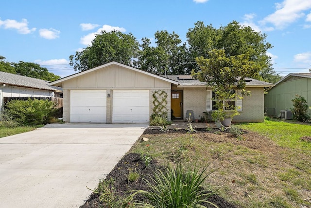 4708 Turnstone Dr, Austin, TX 78744 - view of front of home featuring brick siding, roof mounted solar panels, an attached garage, concrete driveway, and central AC unit