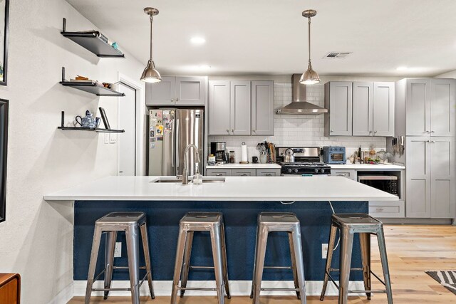 4708 Turnstone Dr, Austin, TX 78744 - kitchen with wall chimney exhaust hood, stainless steel appliances, open shelves, a sink, and gray cabinets