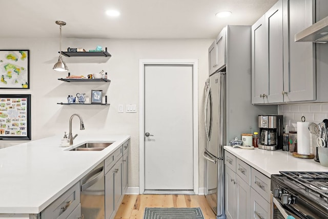 4708 Turnstone Dr, Austin, TX 78744 - kitchen featuring appliances with stainless steel finishes, a sink, gray cabinets, light wood finished floors, and light countertops