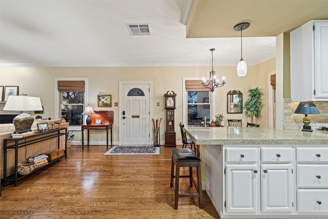 40 Tournament Way Unit G-32, The Hills, TX 78738 - kitchen with white cabinets, light countertops, a peninsula, a chandelier, and tasteful backsplash