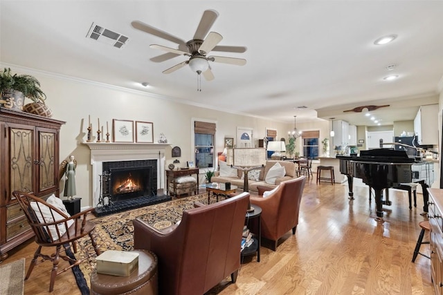 40 Tournament Way Unit G-32, The Hills, TX 78738 - living room with a ceiling fan, crown molding, a lit fireplace, and light wood-style floors