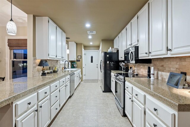 40 Tournament Way Unit G-32, The Hills, TX 78738 - kitchen with stainless steel appliances, a sink, tasteful backsplash, white cabinets, and light countertops