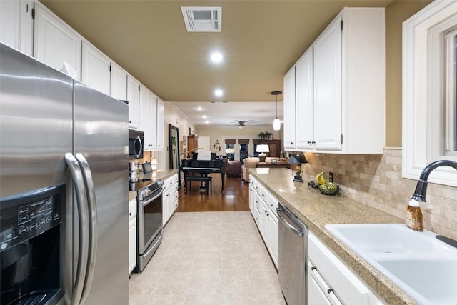40 Tournament Way Unit G-32, The Hills, TX 78738 - kitchen with appliances with stainless steel finishes, a sink, white cabinetry, recessed lighting, and light countertops