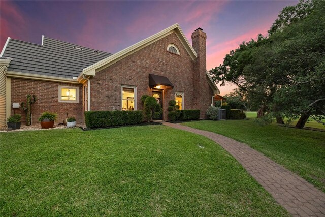 40 Tournament Way Unit G-32, The Hills, TX 78738 - view of front of house with a chimney, brick siding, and a yard