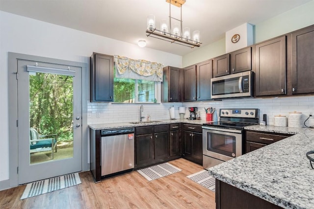 12160 Abbey Glen Ln, Austin, TX 78753 - kitchen featuring stainless steel appliances, dark brown cabinets, light wood finished floors, and decorative backsplash