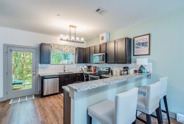 12160 Abbey Glen Ln, Austin, TX 78753 - kitchen with stainless steel appliances, a peninsula, tasteful backsplash, and a kitchen bar