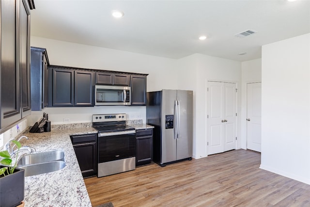 301 Wonderful Life Way, Jarrell, TX 76537 - kitchen with stainless steel appliances, a sink, light wood-type flooring, baseboards, and recessed lighting