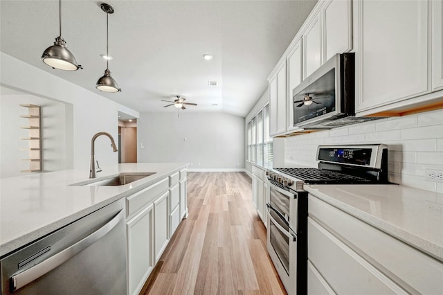 365 Victoria Peak Loop, Dripping Springs, TX 78620 - kitchen with stainless steel appliances, a sink, a ceiling fan, light wood-type flooring, and decorative backsplash