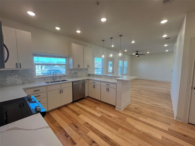 2105 Tiger Trl Unit 603, Round Rock, TX 78665 - kitchen with dishwasher, a sink, light wood-style floors, decorative backsplash, and recessed lighting