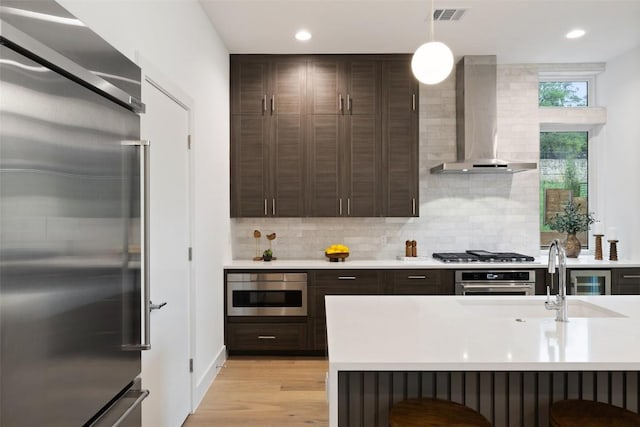 900 S 2nd St Unit 20, Austin, TX 78704 - kitchen with appliances with stainless steel finishes, island range hood, dark brown cabinetry, light countertops, and recessed lighting