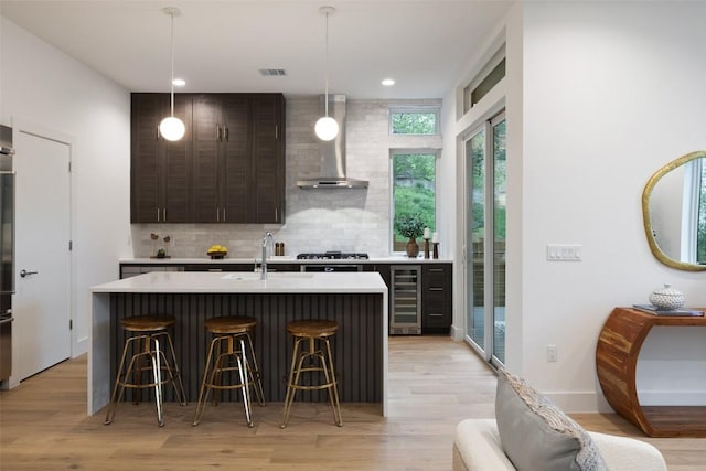 900 S 2nd St Unit 20, Austin, TX 78704 - kitchen with wall chimney exhaust hood, a sink, a kitchen breakfast bar, light countertops, and recessed lighting