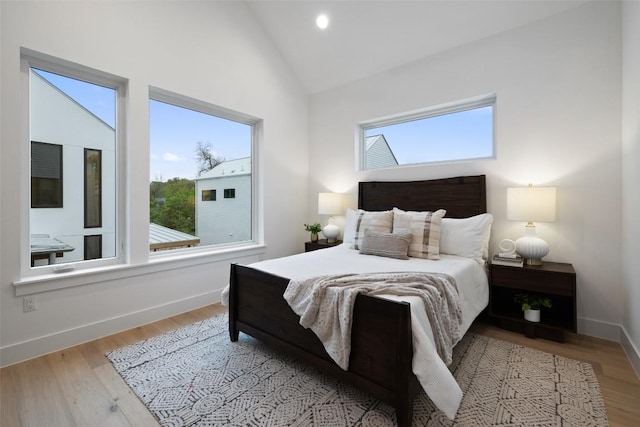 900 S 2nd St Unit 20, Austin, TX 78704 - bedroom featuring multiple windows, wood finished floors, baseboards, and high vaulted ceiling