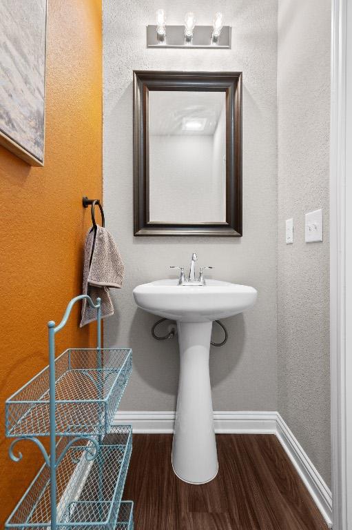 8012 Mandela Bnd, Austin, TX 78744 - bathroom with wood finished floors, baseboards, and a sink