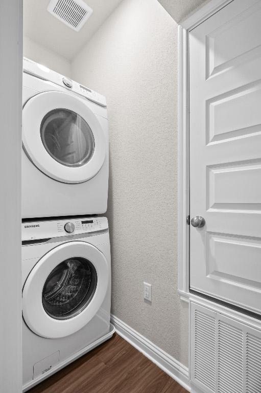 8012 Mandela Bnd, Austin, TX 78744 - washroom with stacked washer / drying machine, dark wood-style flooring, and baseboards
