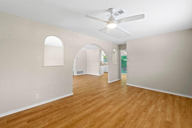 3103 Steck Ave, Austin, TX 78757 - spare room featuring ceiling fan, light wood finished floors, and arched walkways