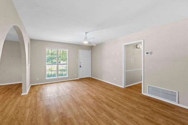 3103 Steck Ave, Austin, TX 78757 - unfurnished room featuring light wood-style flooring, baseboards, arched walkways, and ceiling fan