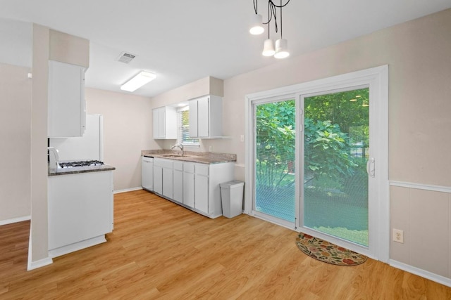 3103 Steck Ave, Austin, TX 78757 - kitchen featuring light wood-style flooring, a sink, white cabinets, white appliances, and pendant lighting
